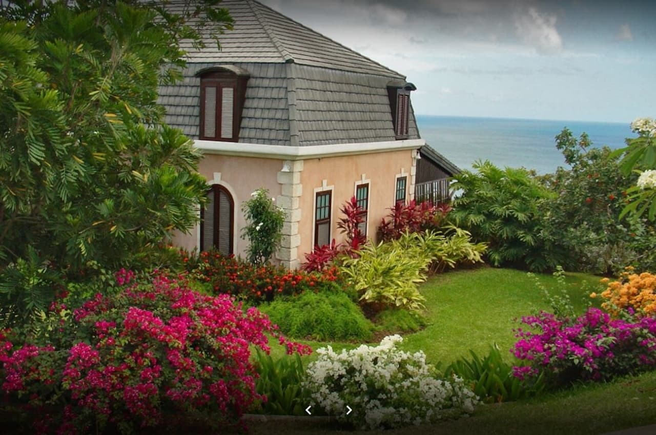 Peach-colored tropical villa with gardens overlooking the ocean in Tobago